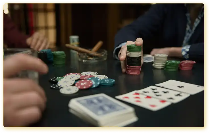 Op de foto is een spannend moment tijdens een pokerspel vastgelegd, waarbij de spelers inzetten plaatsen en de tafel bezaaid is met fiches, kaarten en accessoires, wat de sfeer van een klassiek gokspel in een besloten ruimte oproept.